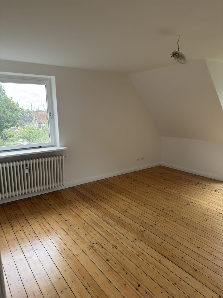 Helles Zimmer mit Holzdielen und Fenster